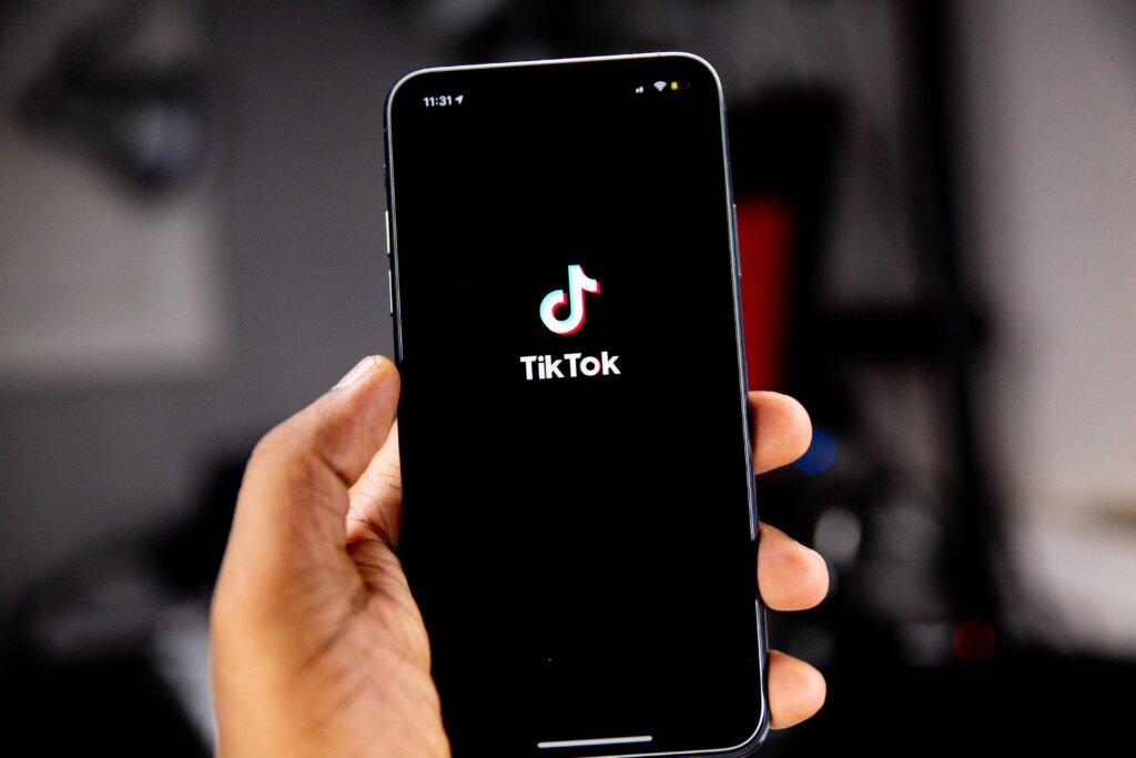 TikTok logo on a black background on an iPhone screen